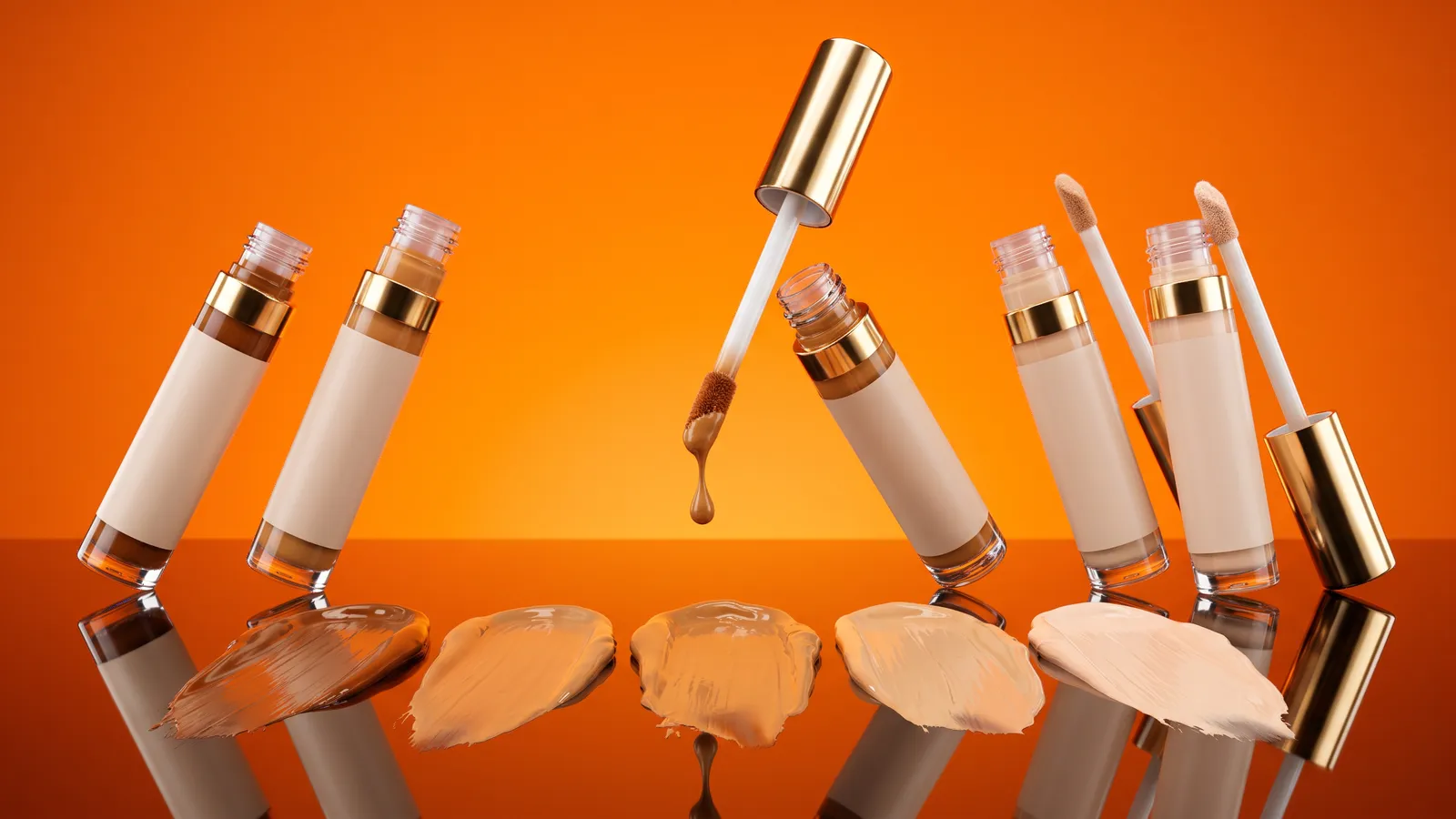 Unbranded liquid concealer wands and swatches in several skin tones on a glossy surface against a bright tangerine backdrop
